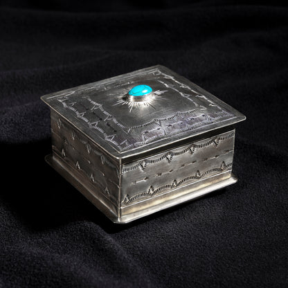 Handmade J. Alexander German silver box with turquoise cabochon sunburst design on dark fabric background