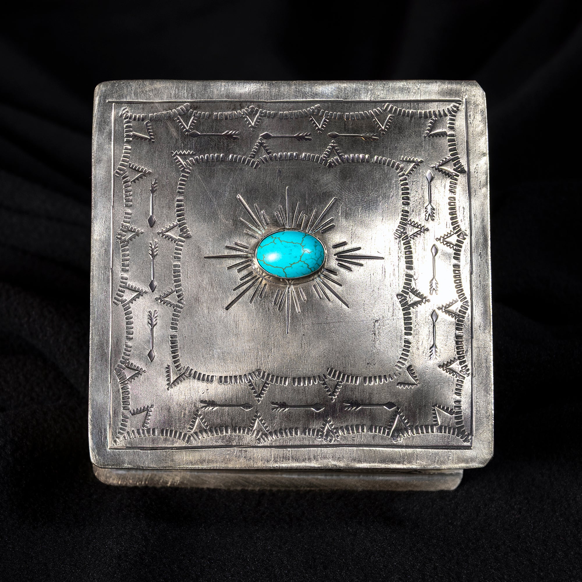 Top view of J. Alexander German silver sunburst box with center turquoise stone and hand-stamped Western pattern