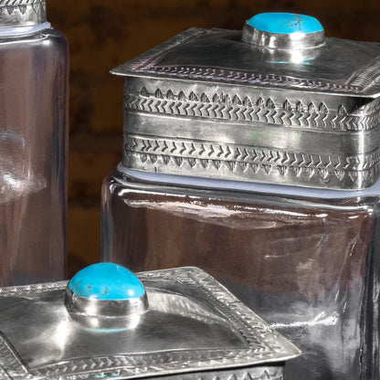 Close-up of thick glass base and silver lid craftsmanship on J. Alexander turquoise decanter