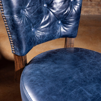 Tufted blue leather backrest with nailhead trim on Western bar stool
