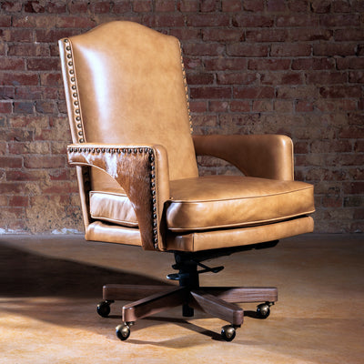 Tan leather and cowhide Western desk chair with nailhead trim and casters