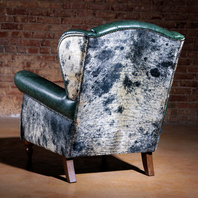 Back view of custom cowhide accent chair featuring rustic leather and detailed stitching – Cattleman’s Retreat
