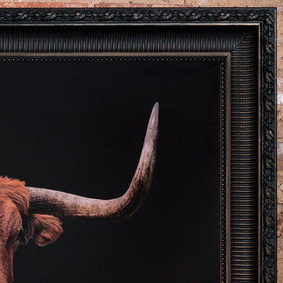 Close-up of framed longhorn art showing horn detail and carved black frame.