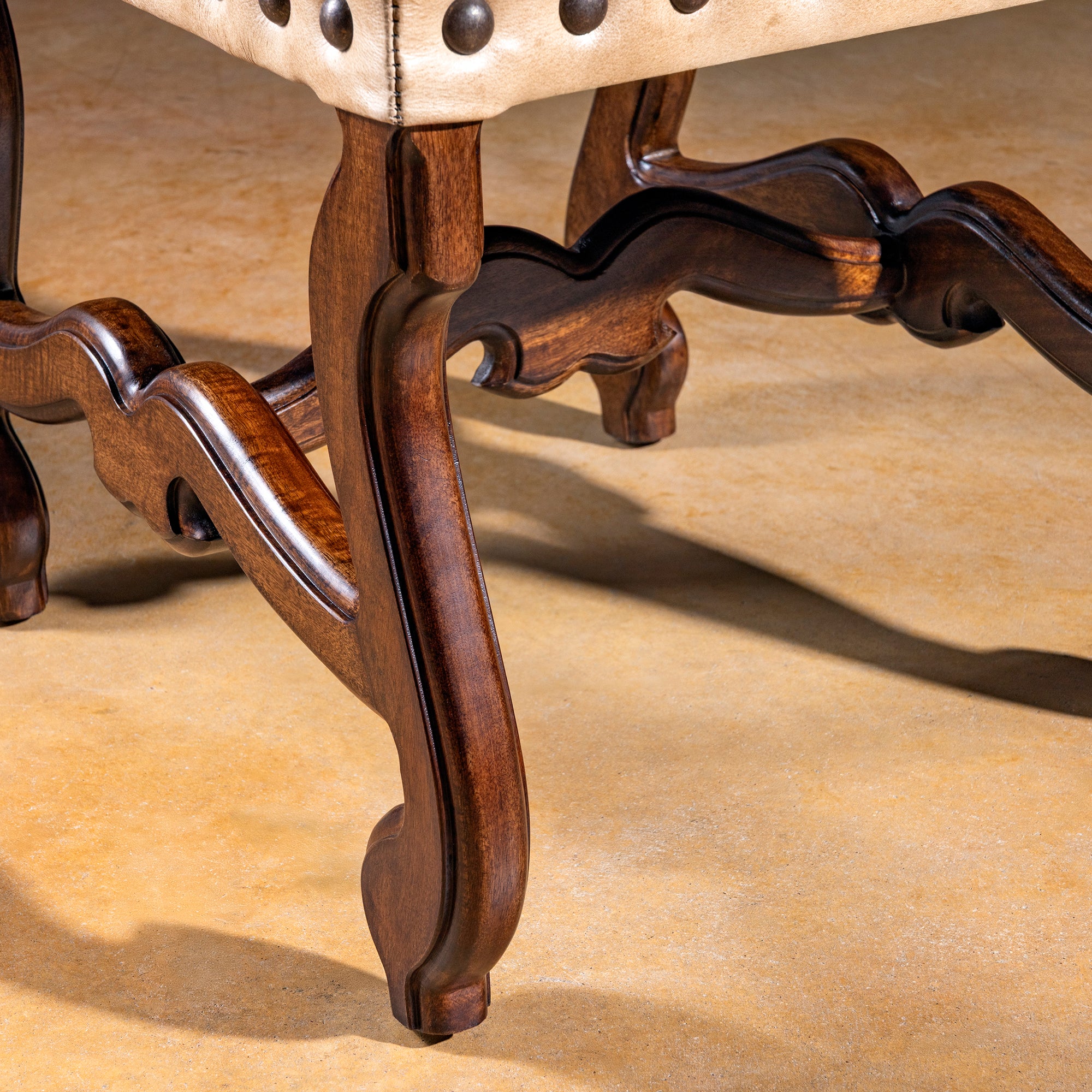 Close-up of carved alder wood legs of the Mariposa Crest Dining Chair