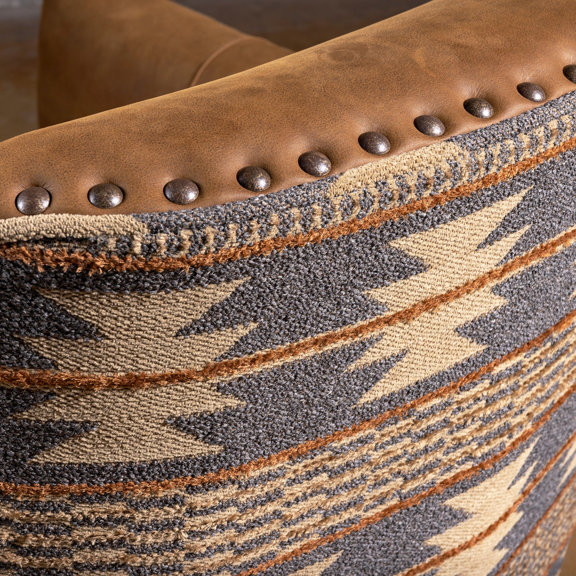 Nailhead trim detail on Pendleton fabric and leather swivel chair