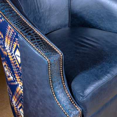 Midnight Caballero western swivel chair close-up with blue croc-embossed leather trim, antique nailheads, and distressed top-grain leather