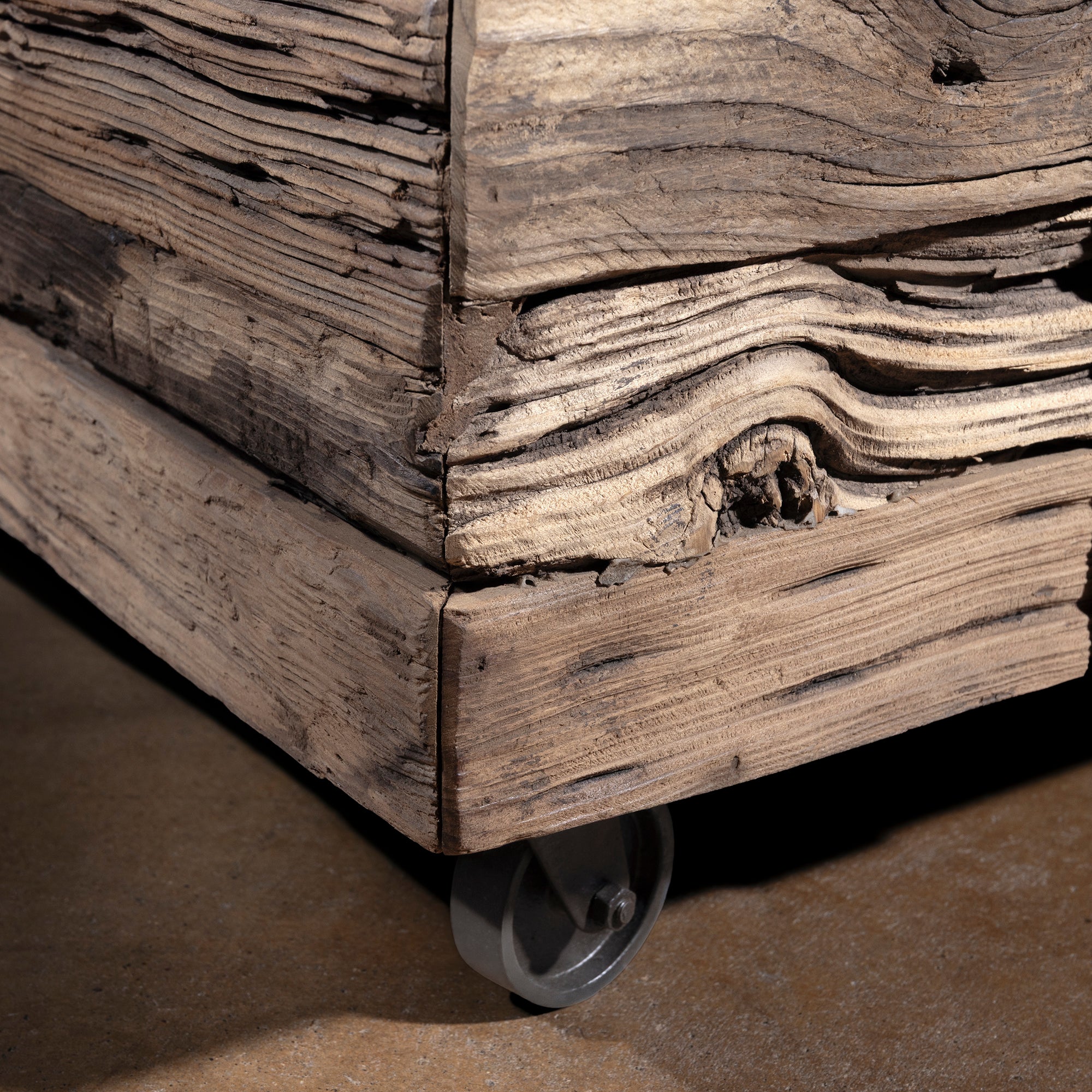 Bottom corner detail of Outlaw Freight Trunk Coffee Table with weathered wood and caster wheels