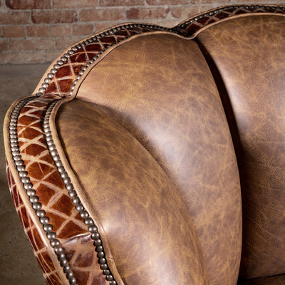 Palacio Bronce Western Leather Swivel Chair detail with diamond-embossed leather, antique nailheads, piping, and curved crest.