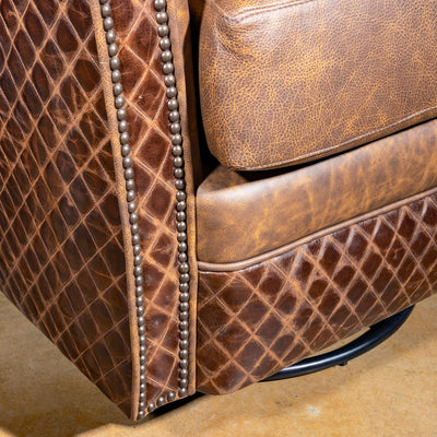Palacio Bronce Western Leather Swivel Chair close-up with distressed leather, diamond-embossed panels, nailheads, and swivel base.