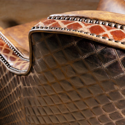 Palacio Bronce Western Leather Swivel Chair close-up with distressed leather, diamond-embossed panels, nailheads, and swivel base.