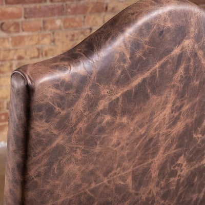 Closeup of distressed brown top grain leather on Pecos Canyon high back dining chair