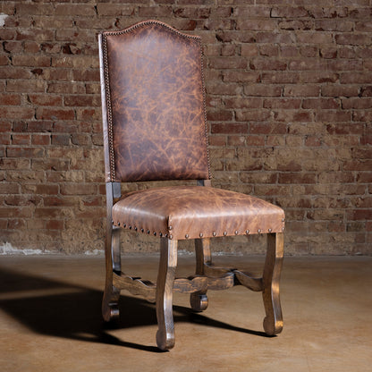 Front hero view of Pecos Canyon Western leather dining chair in rustic brick loft setting