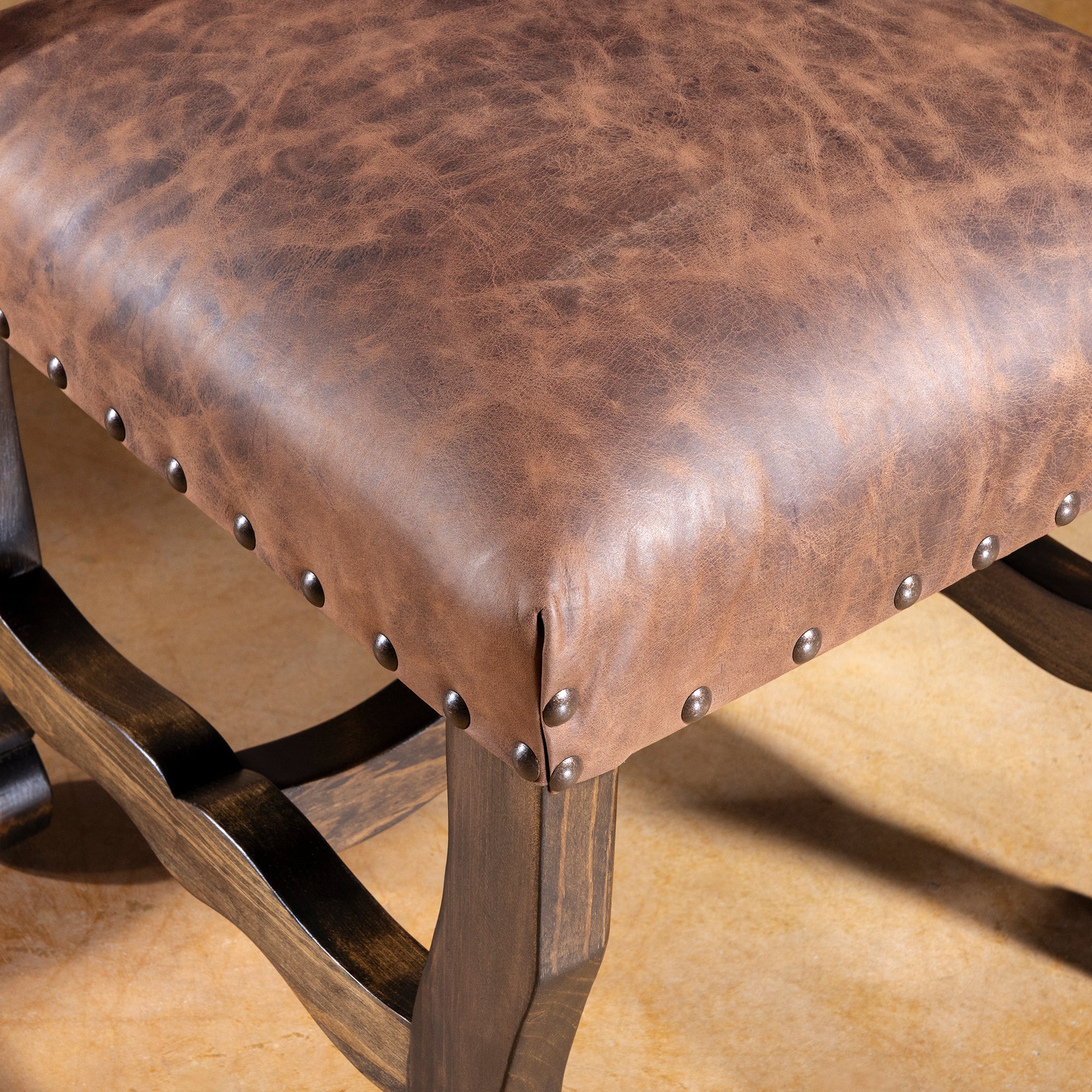Seat cushion closeup showing distressed leather and nailhead border on Pecos Canyon dining chair