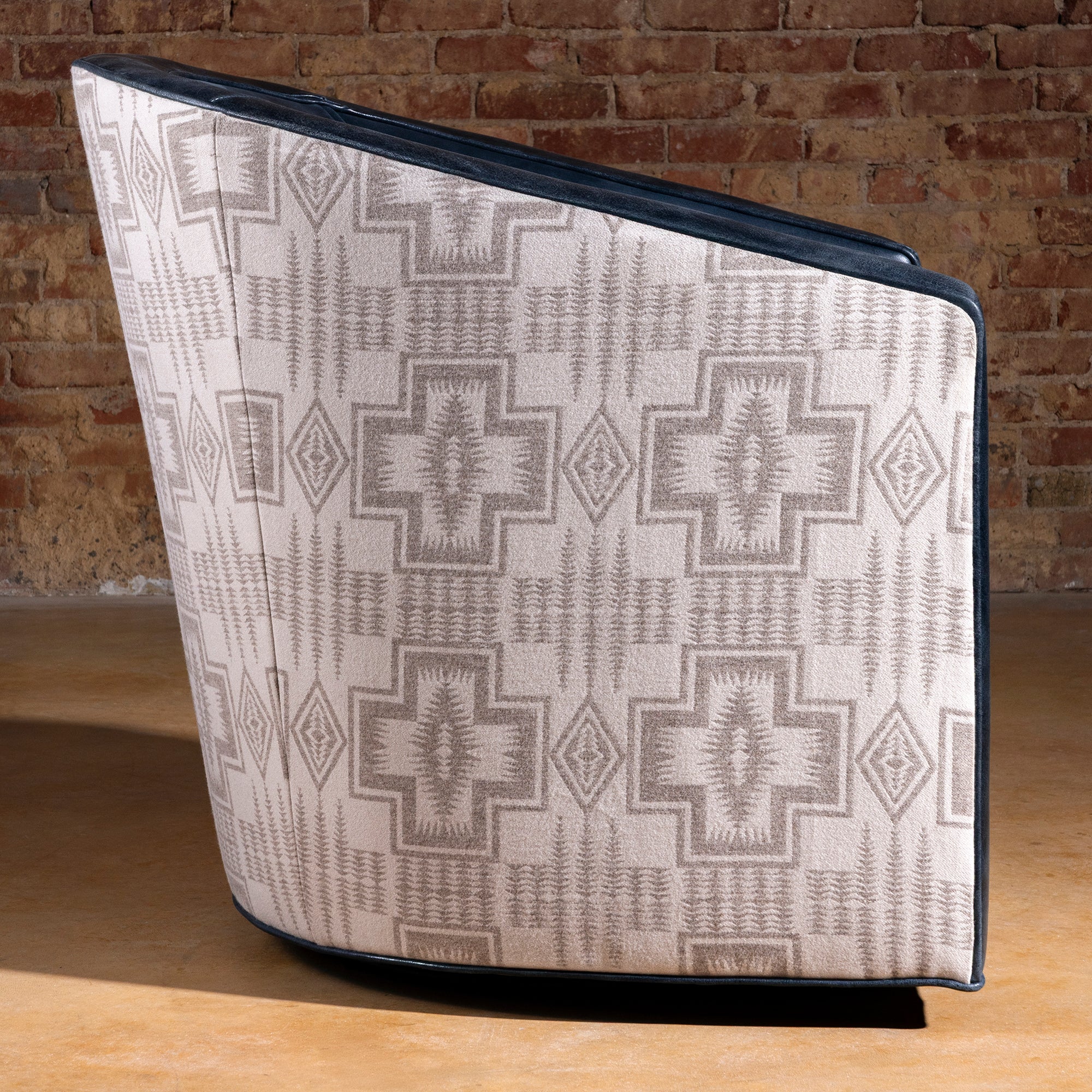 Profile view of the Silver Mesa Swivel Chair with navy top-grain leather seat and Pendleton fabric sides