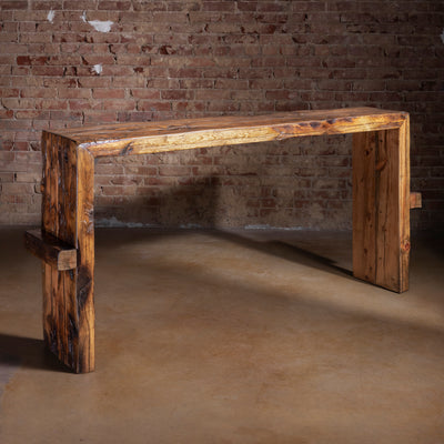 Prairie Ledger reclaimed wood console table full view against brick wall