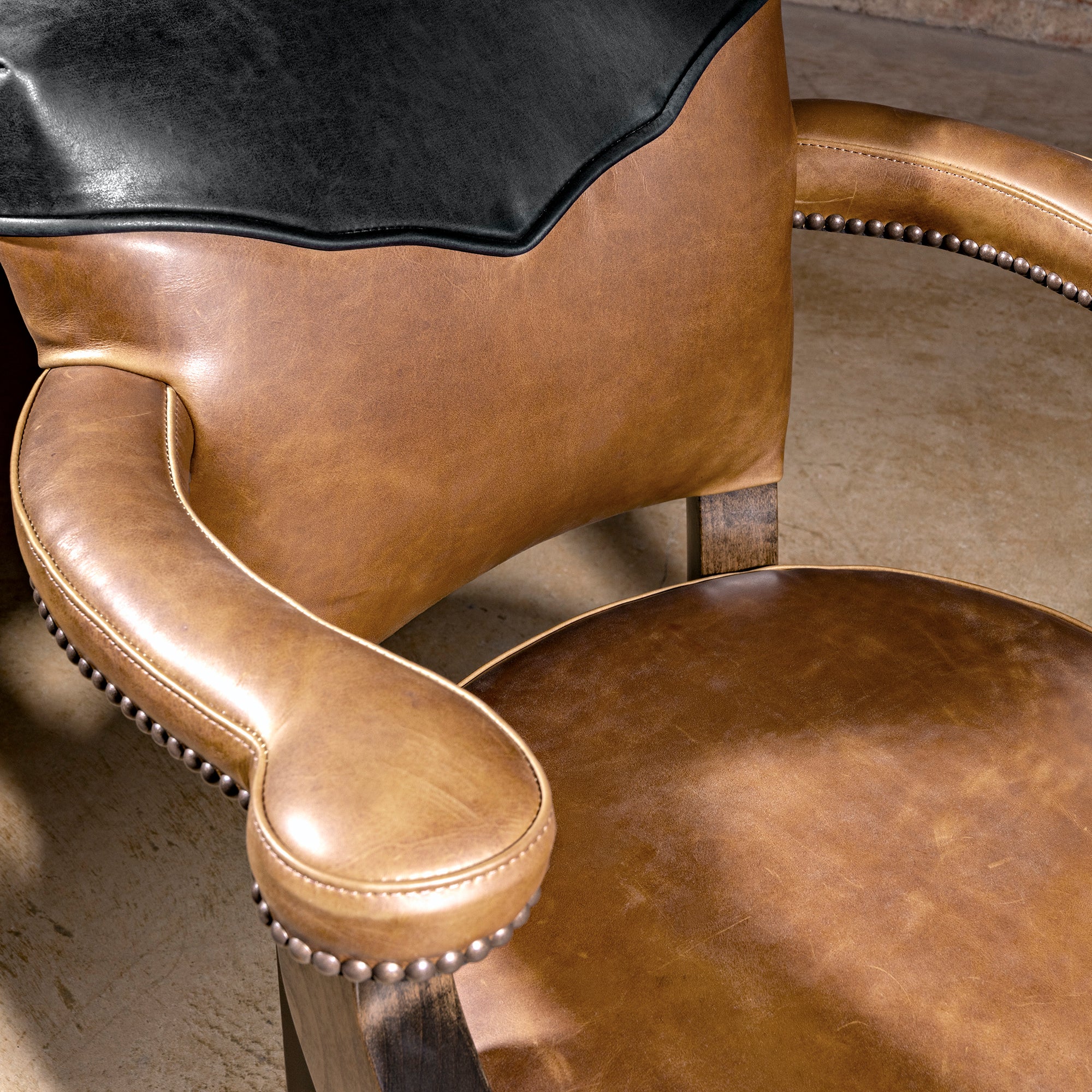 Presidio Dealer Chair close view of tan leather seat and arm on a Western poker chair with nailhead trim and wood frame