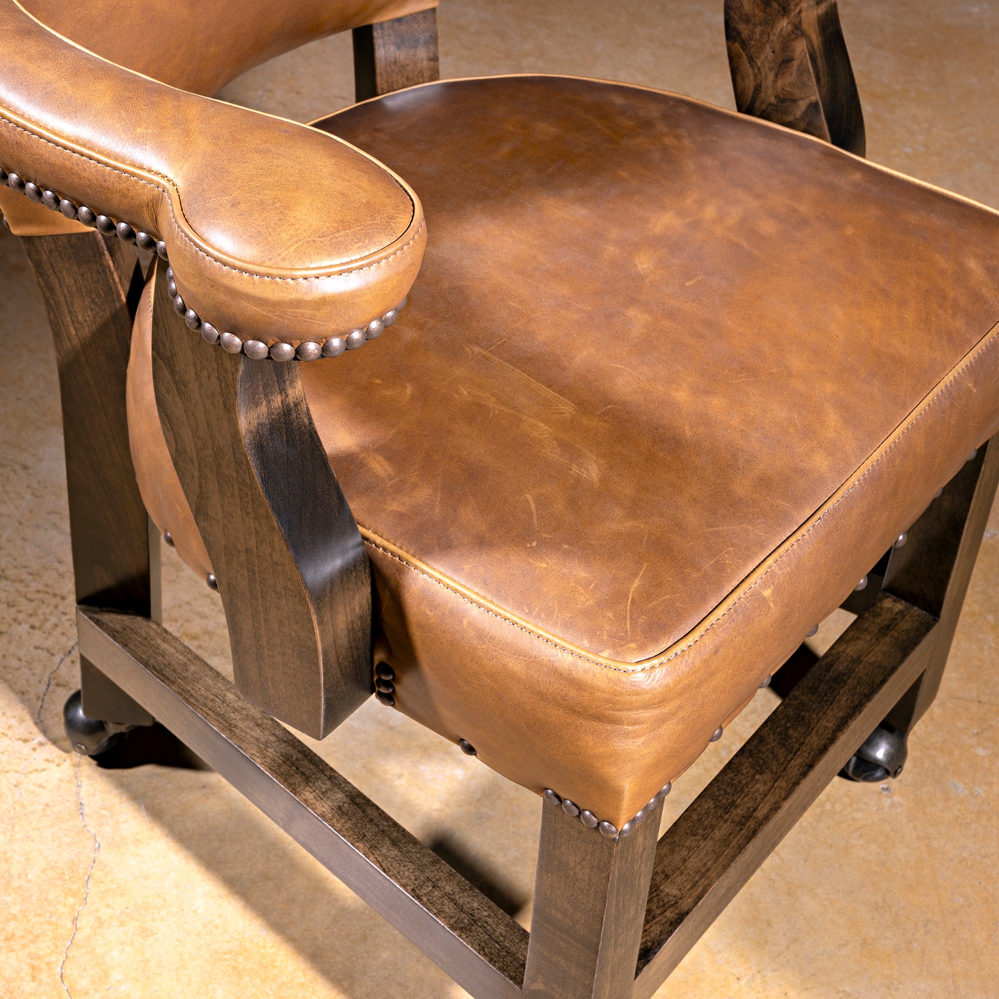 Presidio Dealer Chair black yoke back detail on a Western poker chair with tan leather, nailheads, and alder wood base
