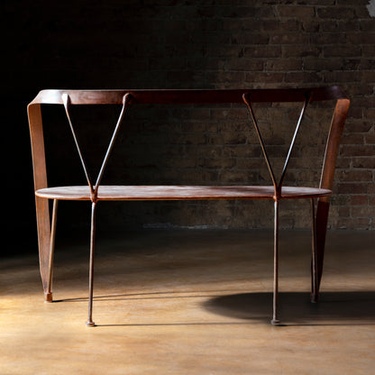 Railspur Gallery Bench back view showing hand forged Western iron frame against brick wall