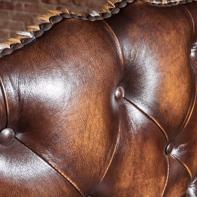 Button-tufting detail on top-grain leather executive Western desk chair
