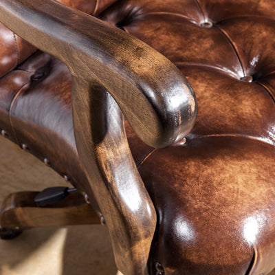 Close-up of wood arm detail on tufted leather Western office chair