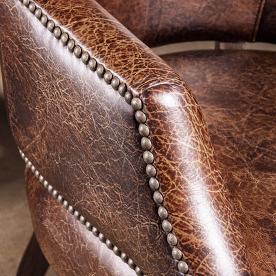 Close-up of leather arm with nailhead trim on Western game chair