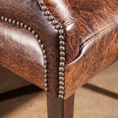 Nailhead trim close-up on distressed leather Western game chair