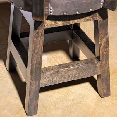 Sable Crest Hideback Bar Stool western cowhide bar stool alderwood base detail with dark finished legs and stretcher support.