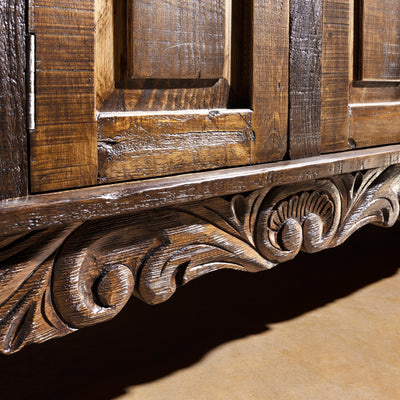 Close-up of hand-carved scroll base on reclaimed wood Western buffet