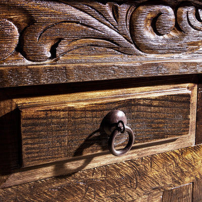 Ring-pull drawer hardware close-up on reclaimed wood carved Western buffet