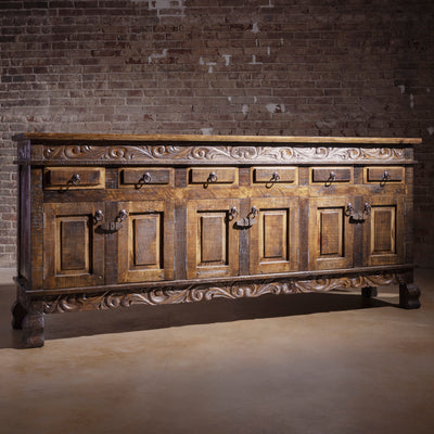 Angled view showing carved doors, drawers, and rustic iron accents on Western buffet