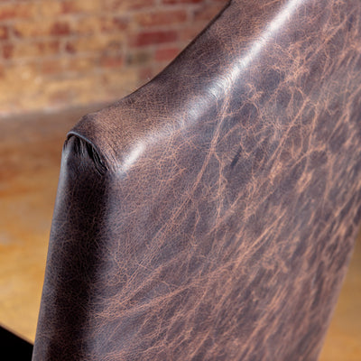 Distressed leather seat and nailhead detail on Western chair