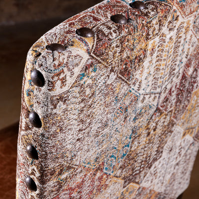 Close-up of antique-style nailhead trim and woven fabric on dining chair