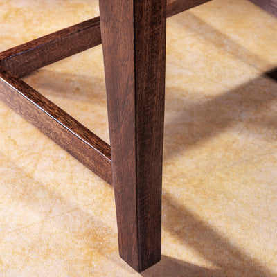 Detail of dark wood leg on handcrafted dining chair