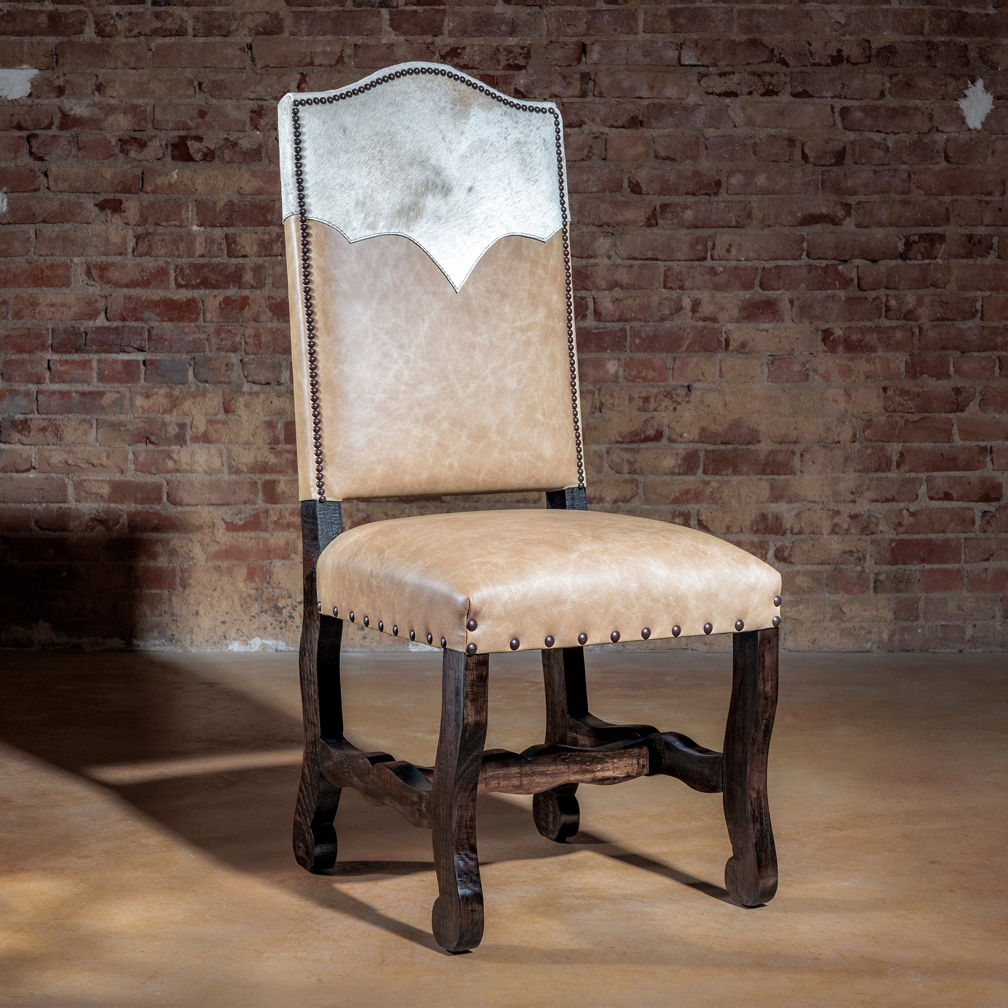 Santa Fe Yoke Dining Chair front view with pale cowhide yoke, tan leather seat, nailhead trim, and dark wood legs