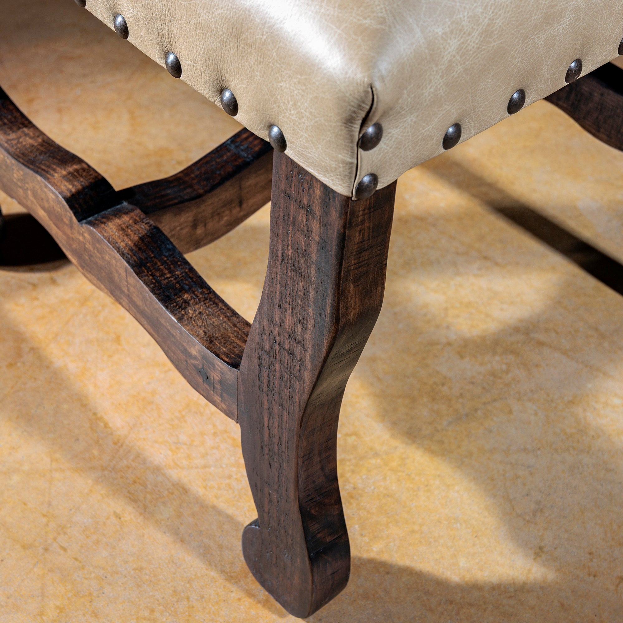 Santa Fe Yoke Dining Chair leg and stretcher detail with dark stained wood and nailhead-trimmed leather seat