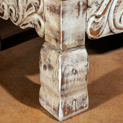 Close-up of carved console leg with distressed wood finish