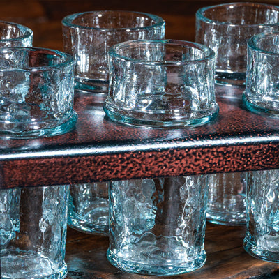 Close-up of textured shot glasses in a copper-finished metal caddy