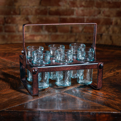 Shot glass set in hammered copper holder on rustic wood table
