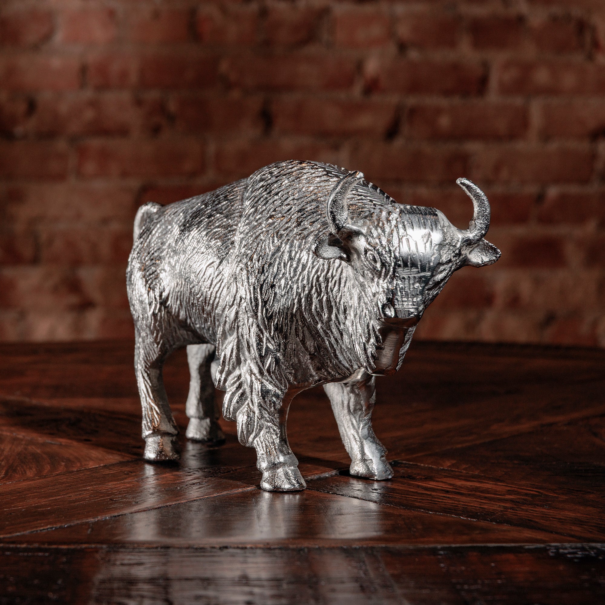 Side angle of silver bull statue with polished finish