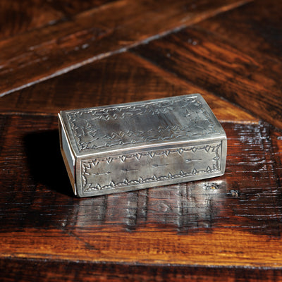 Reverse side of silver matchbox case with etched border design