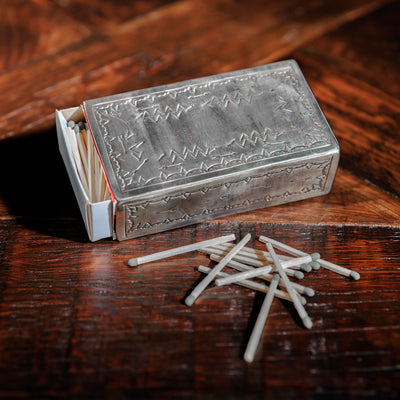 Open silver matchbox holder with matches spilling out by J. Alexander