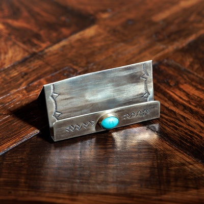 Western-style silver card holder with stamped detail and turquoise centerpiece