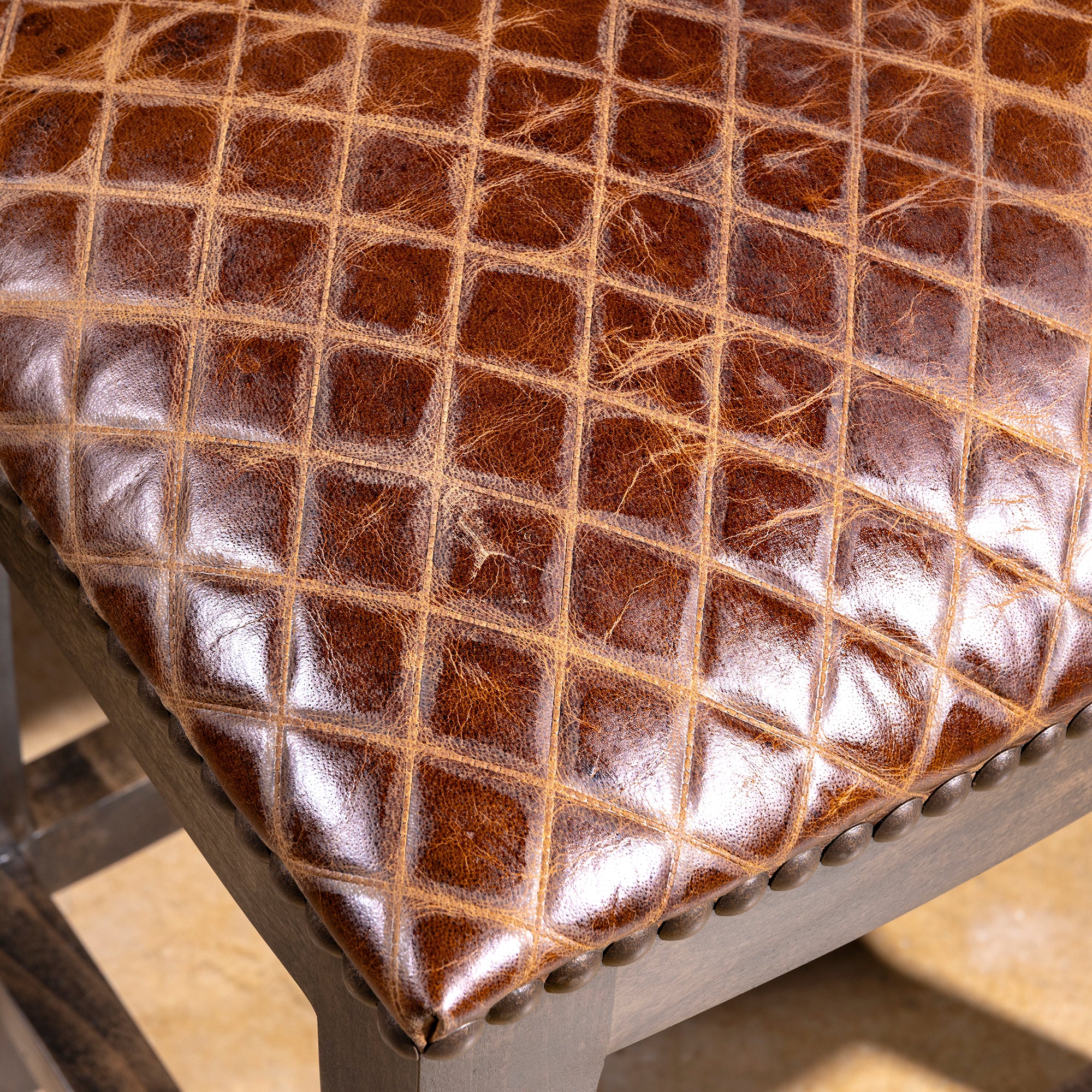 Tascosa Saddle Stool close detail of croc-embossed top-grain leather seat with rich saddle-brown Western texture