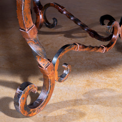 Hand-forged iron scroll leg with rustic patina detail – Into The West