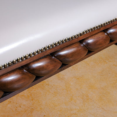 Carved wood detailing and nailhead trim on Western leather bench