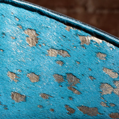 Close-up of turquoise cowhide texture and gold flecking on Western gun holder