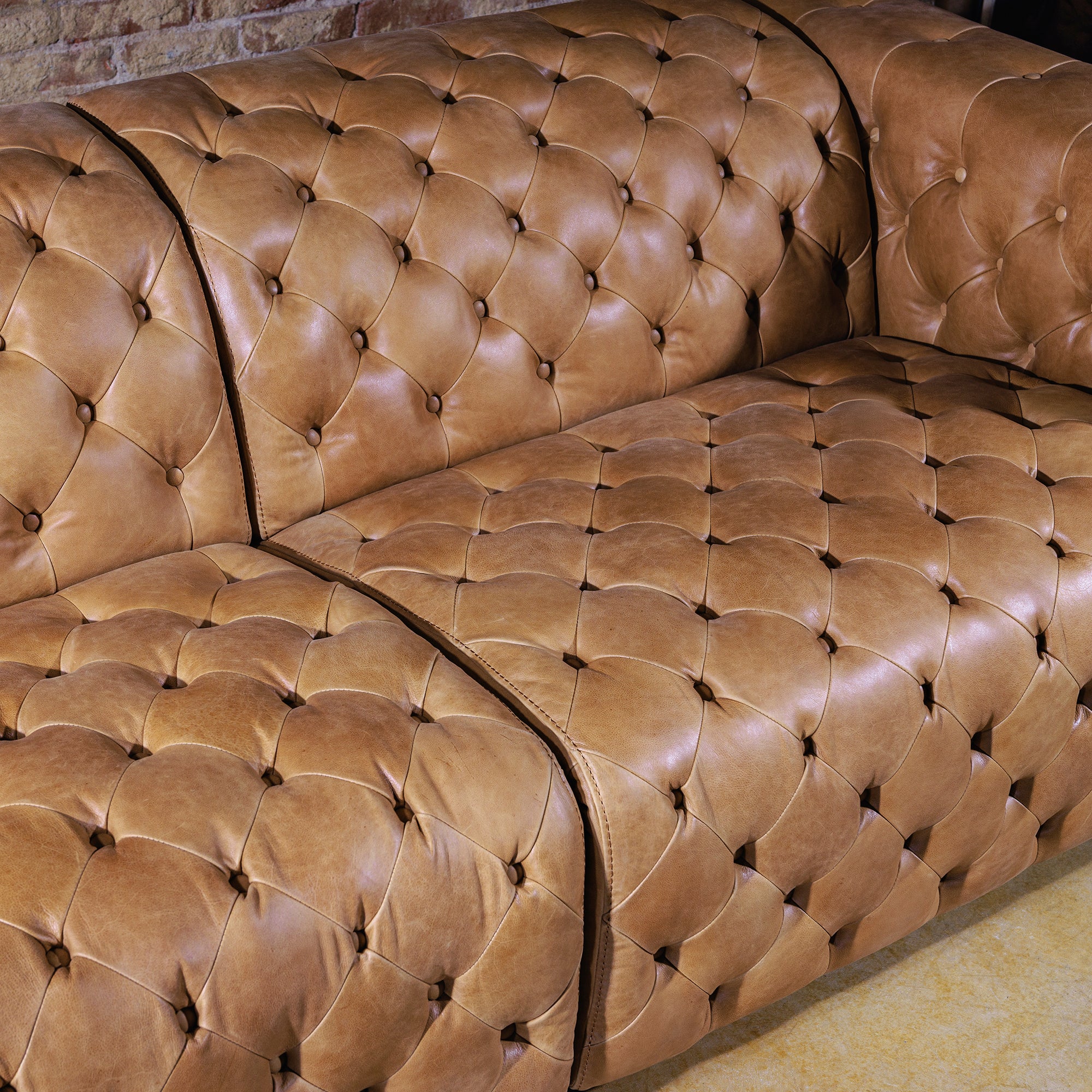 Close-up of hand-tufted seat back and armrest detailing on Western leather sectional