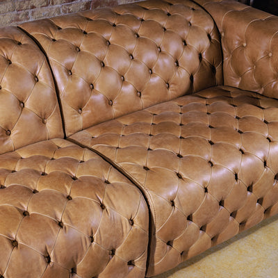 Close-up of hand-tufted seat back and armrest detailing on Western leather sectional