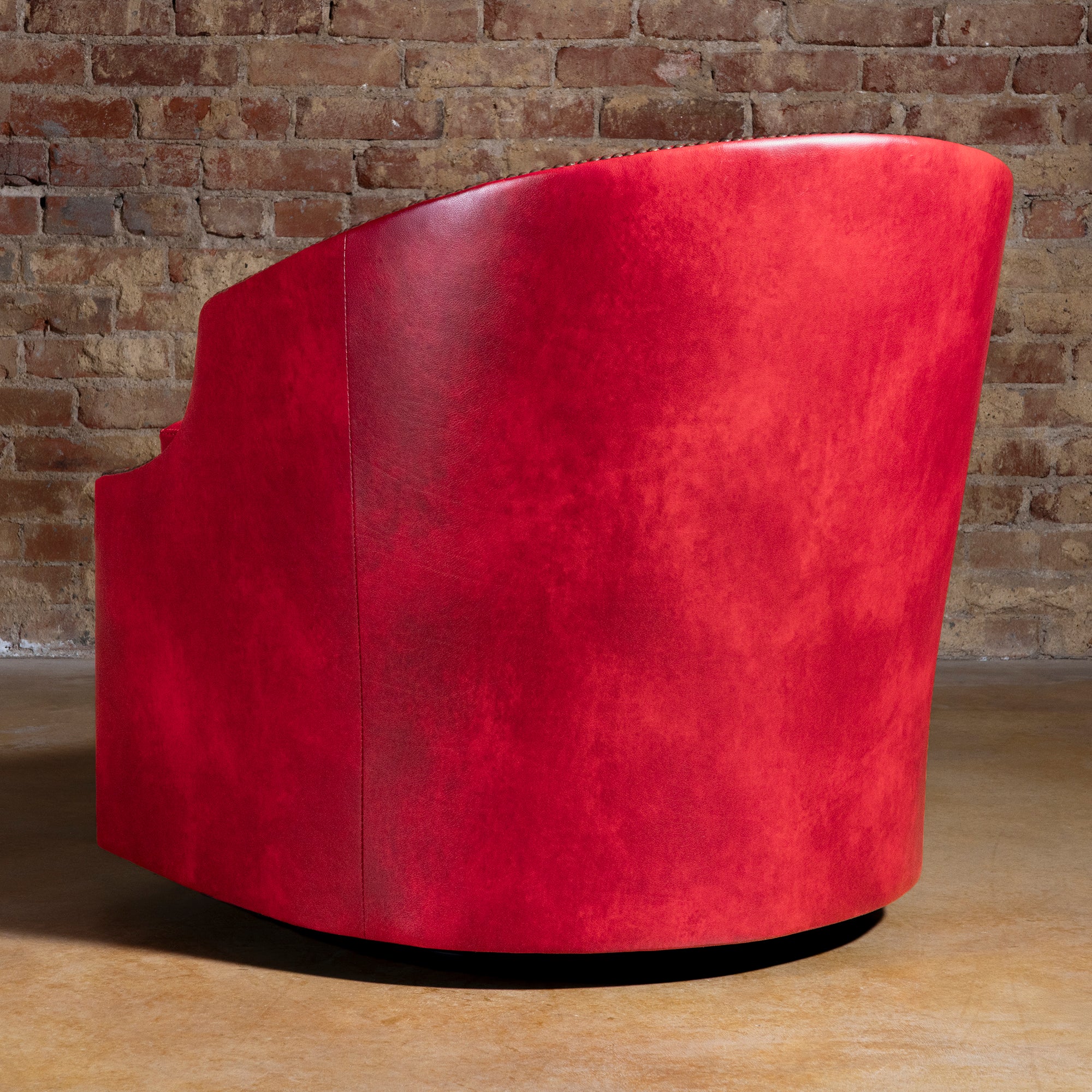 Back view of Vaquera Royale red Western leather swivel chair with curved barrel silhouette