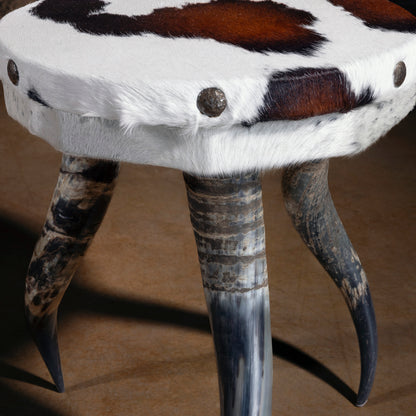 Side view of Vaquero Bullhorn Accent Table showing bullhorn legs and natural hide texture